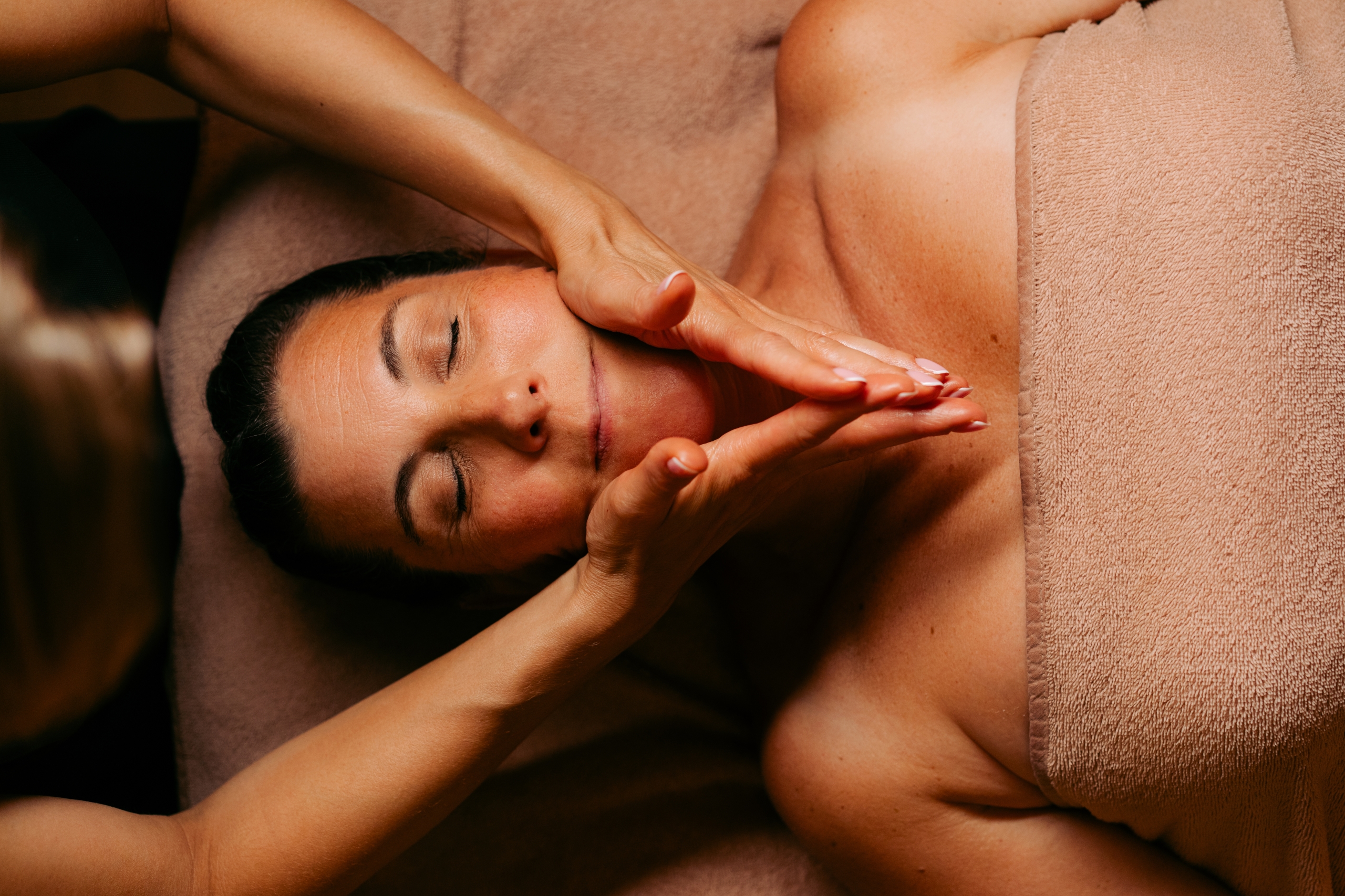 Facialiste réalisant le Massage Signature relaxant du visage d’une cliente chez Terramassa près de Metz