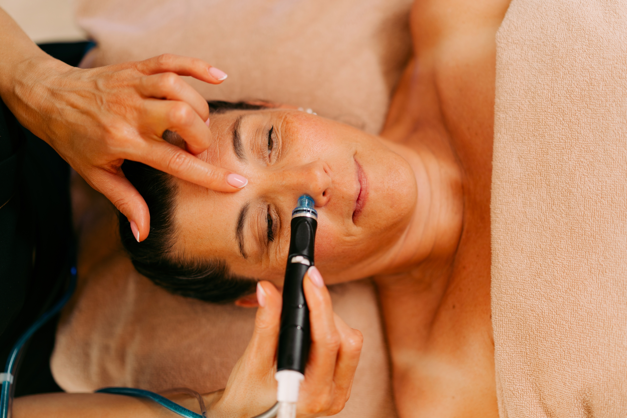 Embout Hydrafacial appliqué sur le visage d’une cliente lors d’un soin chez Terramassa