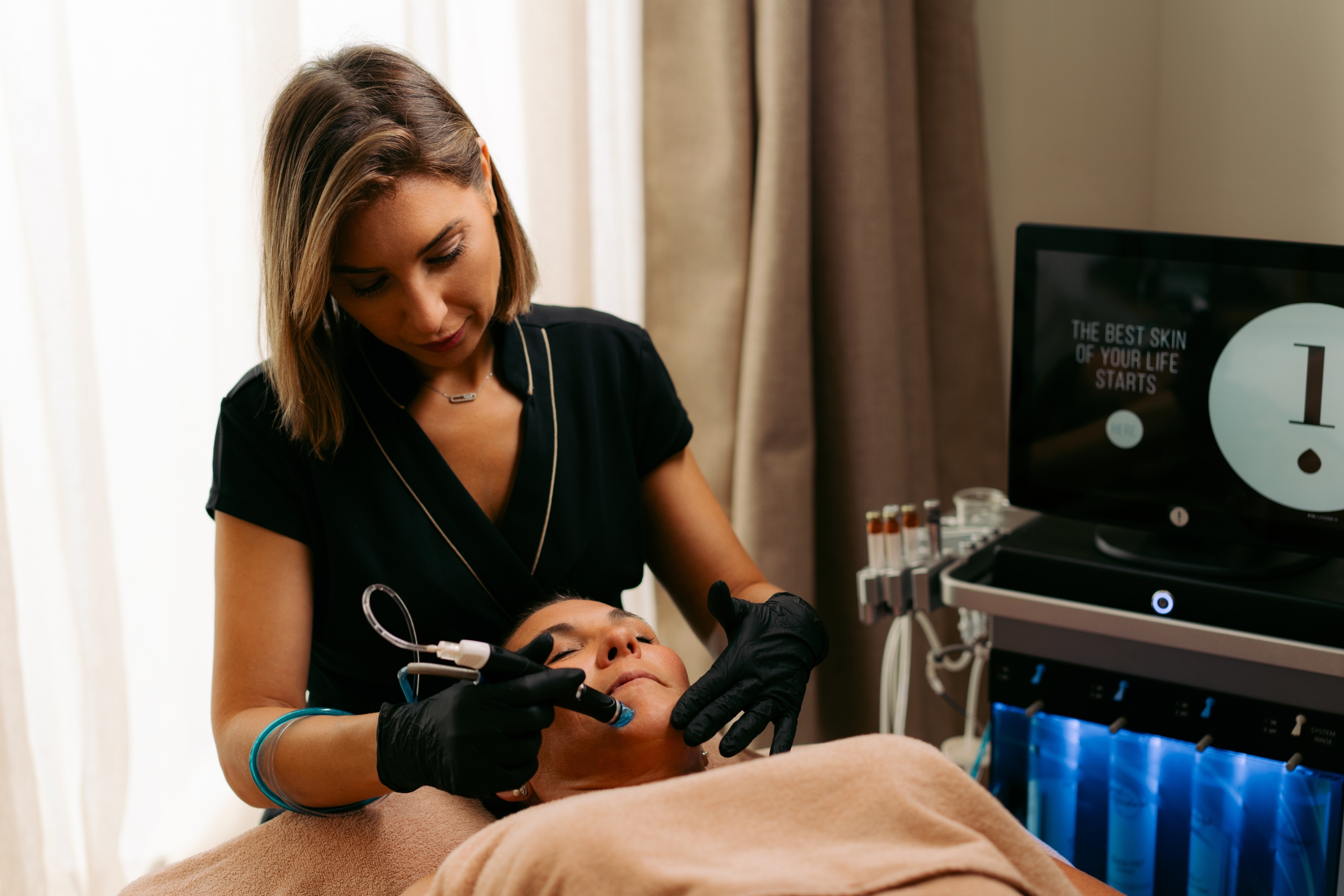 Praticienne réalisant un soin Hydrafacial sur le visage d’une cliente chez Terramassa